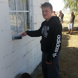 student brushing dirt off a window