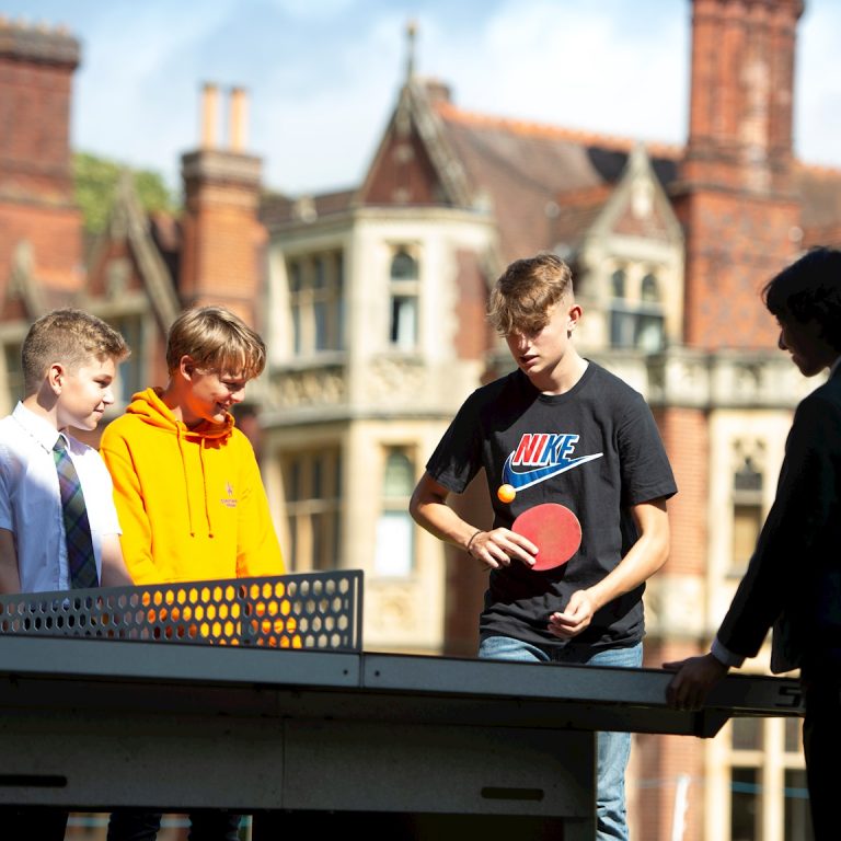 students playing ping pong outdoors