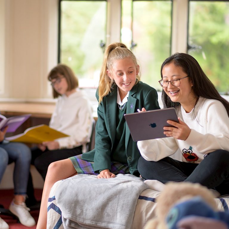 Girls relaxing together and using an ipad