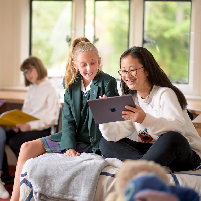 Girls relaxing together and using an ipad