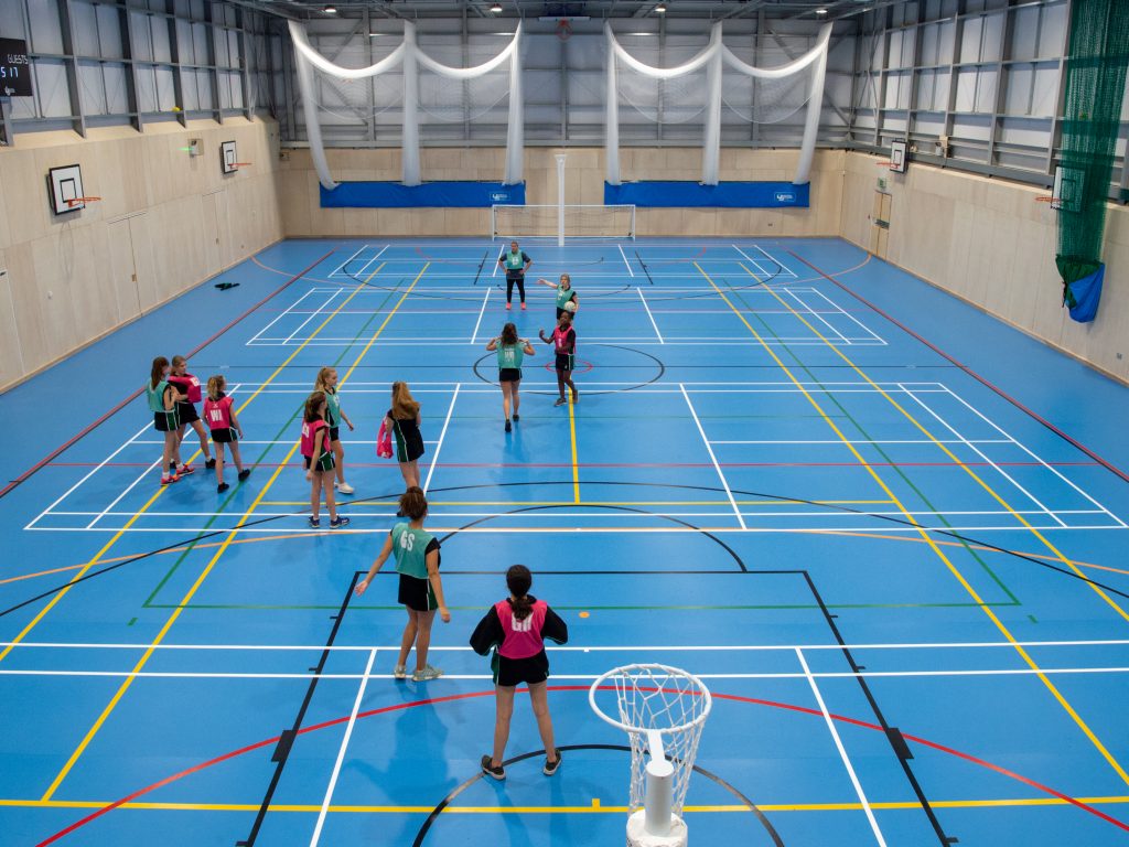 girls playing netball in the indoor court