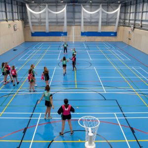 girls playing netball in the indoor court