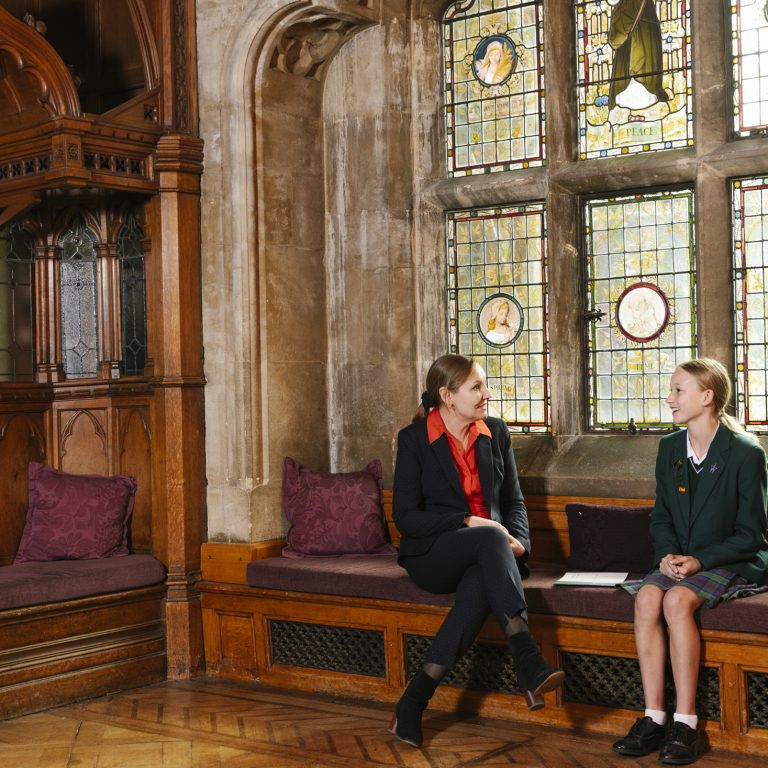 student and teacher sat on a bench