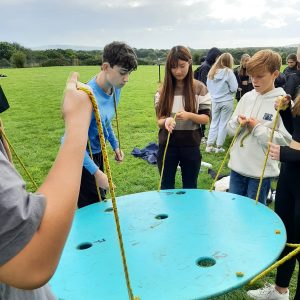 children holding a giant disk up