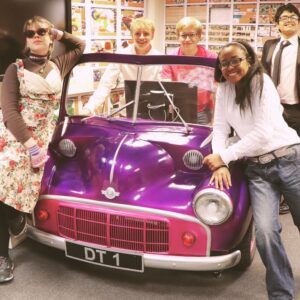 students leaning on a car